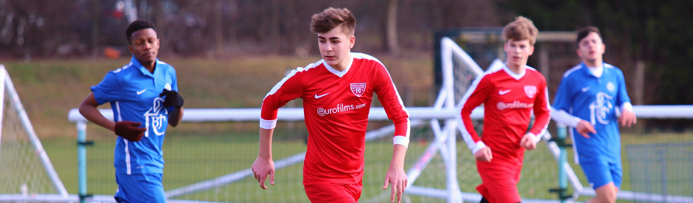 High School Schüler spielen Fußball auf einem Sportplatz in England