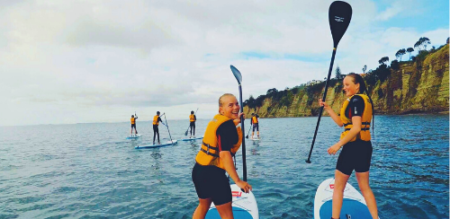 Austauschschülerinnen auf einem Stand Up Paddle Board in Neuseeland