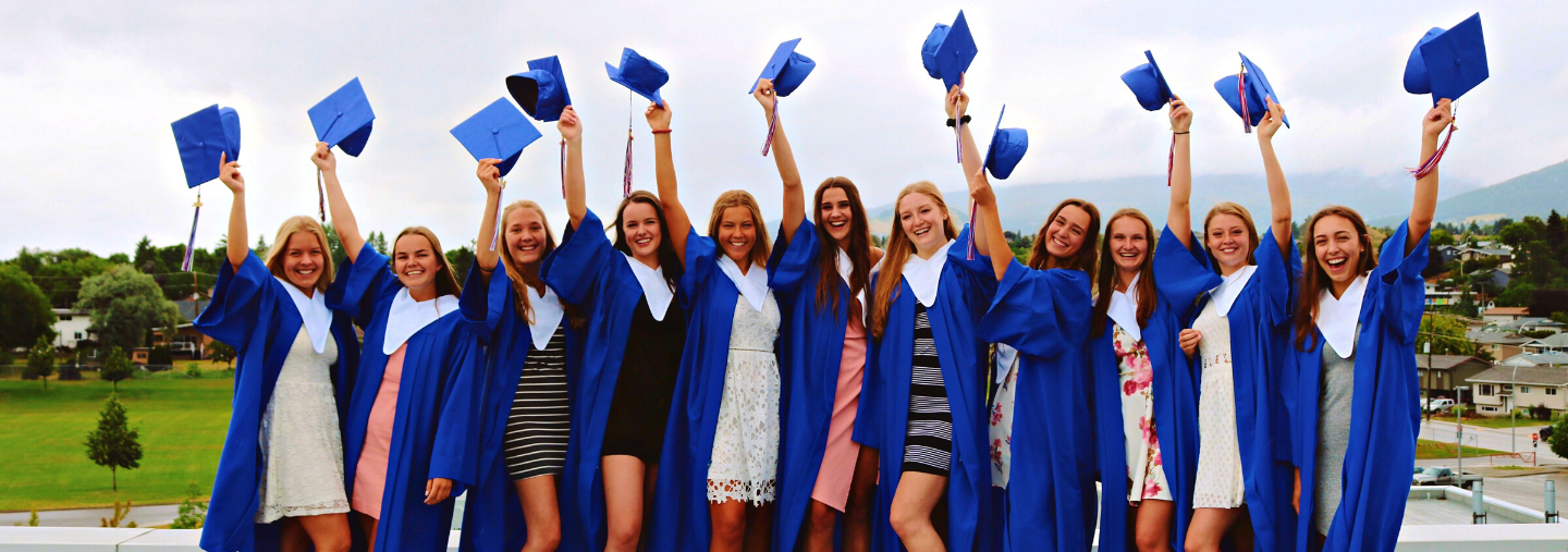 High School Absolventinnen werfen ihre blauen Absolventenhüte in die Luft