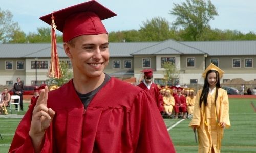 High School Austauschschüler bei seiner Absolventenzeremonie auf dem Sportplatz