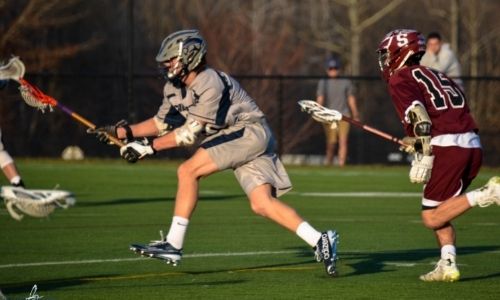 High School Schüler spielen Lacrosse auf einem Sportplatz