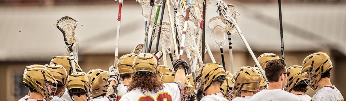 Lacrosse Spieler und Spielerinnen halten ihre Lacrosse Schläger in die Luft