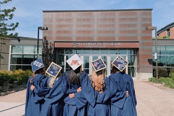 High School Absolventinnen vor dem Schulgebäude