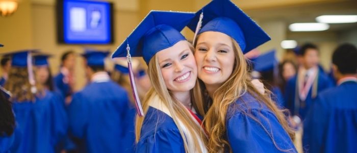 High School Absolventinnen mit Abschlusshüten und Umhängen bei ihrer Abschlusszeremonie in den USA