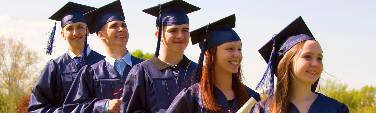 High School Absolventen mit Abschlusshüten und Umhängen bei ihrer Abschlusszeremonie in den USA