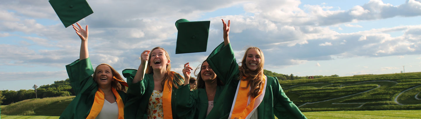 USA High School Absolventen und Absolventinnen werfen ihre Abschlusshüte in die Luft