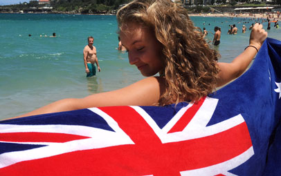 Austauschschülerin mit Australien Flagge am Strand