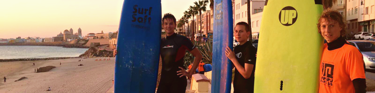 Austauschschüler mit Surfbrettern am Strand in Spanien