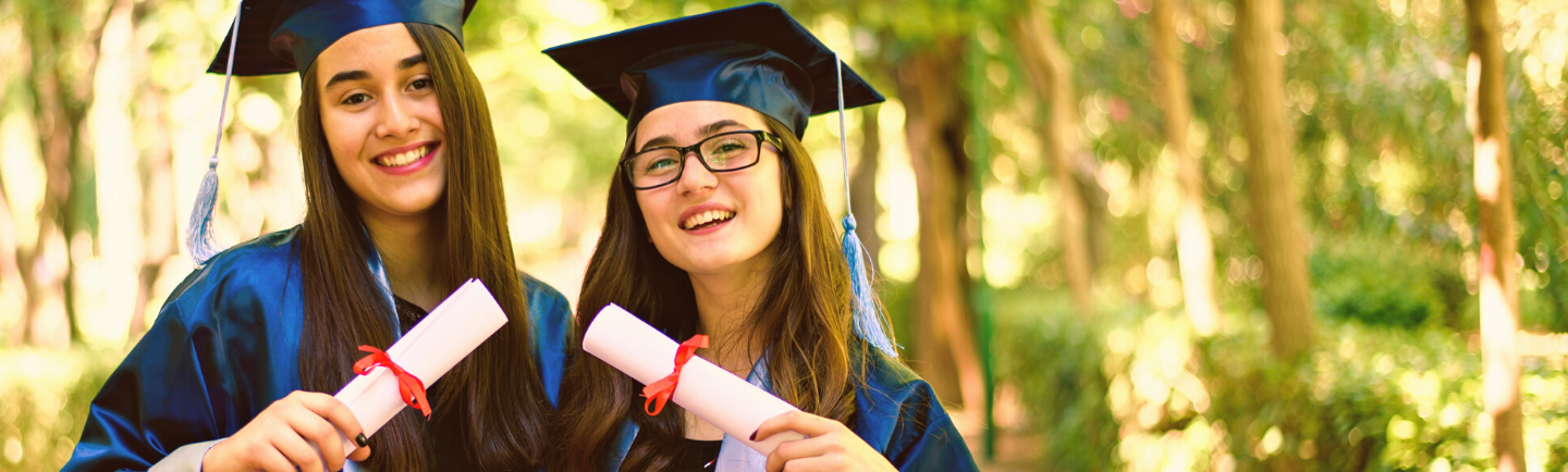 High School Absolventinnen mit Diploma in der Hand umarmen sich