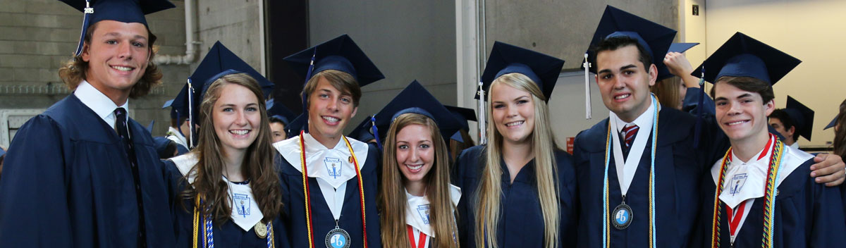 High School Absolventen und Absolventinnen mit blauem Umhang und Hut auf ihrer Absolventenfeier in den USA