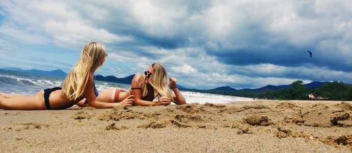 Zwei Austauschschülerinnen liegen am Strand