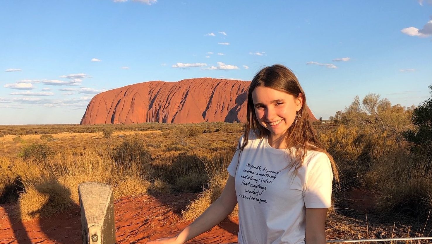 Austauschschülerin vor dem Uluru in der Wüste Australiens