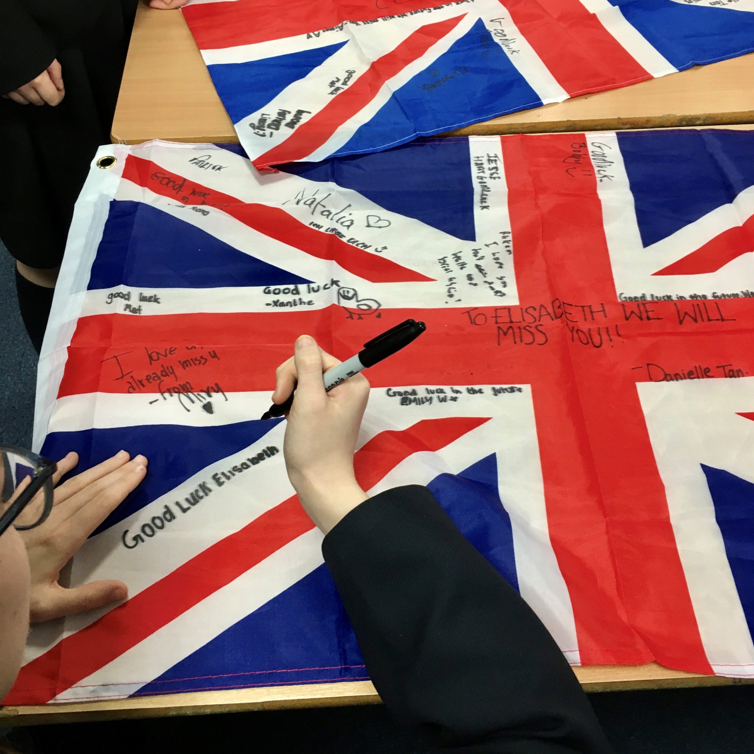 Austauschschülerin unterschreibt auf einer Englandflagge