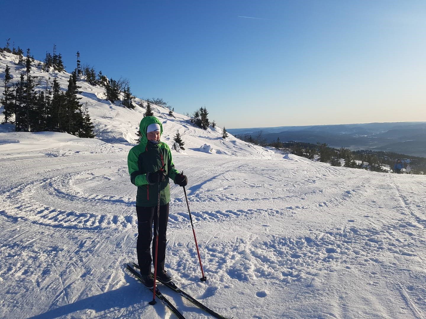 Austauschschülerin fährt bei Sonnenschein und blauem Himmel Ski in Norwegen