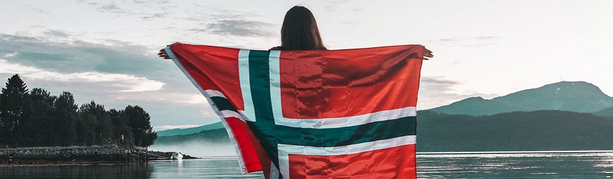 Austauschschülerin hält große Norwegen Flagge hinter ihrem Rücken