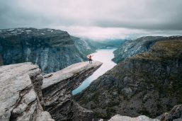 Austauschschüler auf einem Felsvorsprung mit atembreaubendem Blick auf einen Fjord in Norwegen