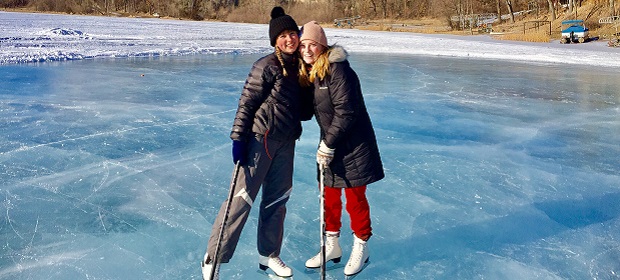Austauschschülerinnen auf einem zugefrorenen See mit Schlittschuhen uns Eishockey Schlägern in Oregon, USA