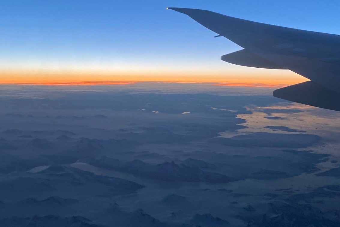 Blick aus dem Flugzeugfenster bei Sonnenuntergang