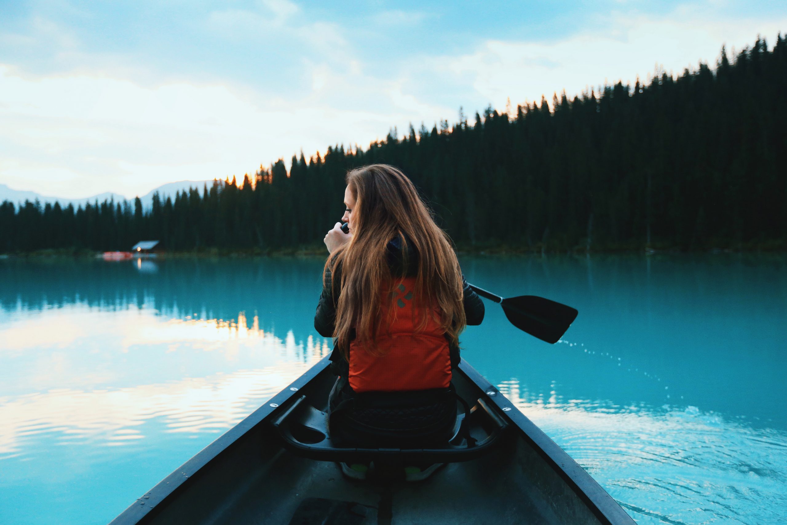 Austauschschülerin fährt Kanu auf einem See in Kanada